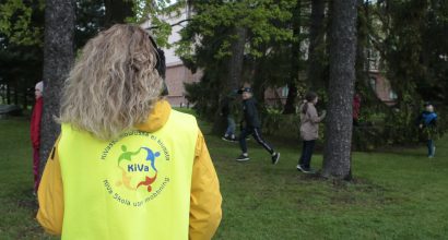Opettaja koulun pihalla päällään KiVa-koulu-liivi