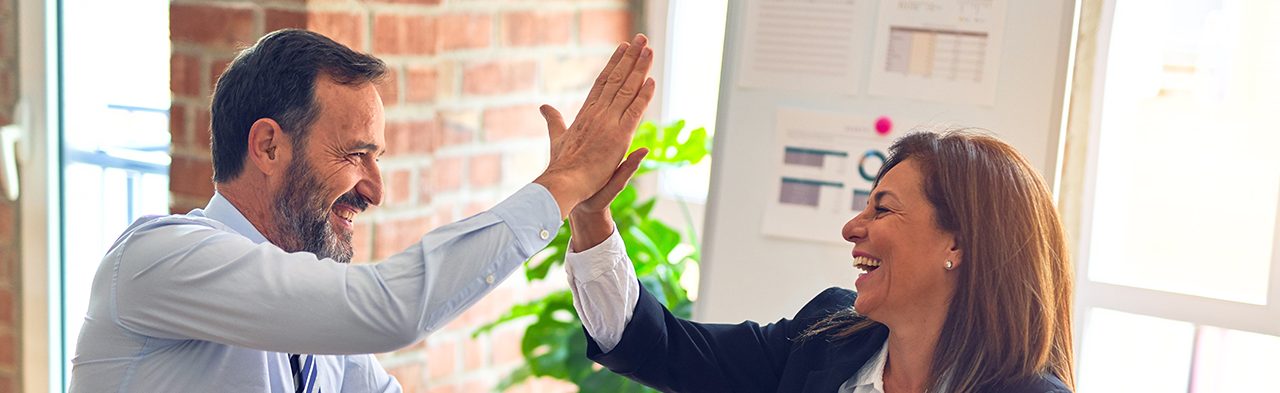 A man and a woman doing high five in an office