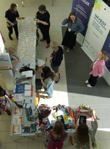 Photo of the info desk from above. A lot of people are around it.