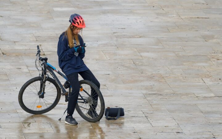 Lonely girl eith bike and cell phone.