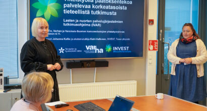 kaksi tutkijaa esittelee tutkimuksen tuloksia kokoushuoneessa.