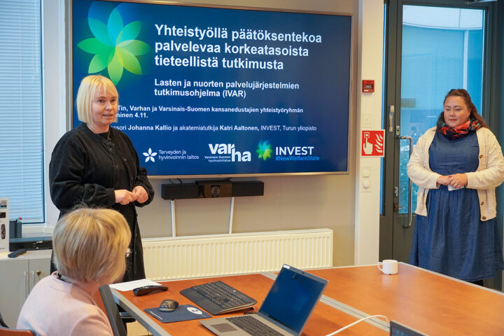 kaksi tutkijaa esittelee tutkimuksen tuloksia kokoushuoneessa.