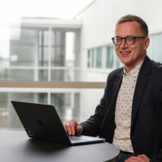 Jani Erola tietokoneen ääressä iloisena.