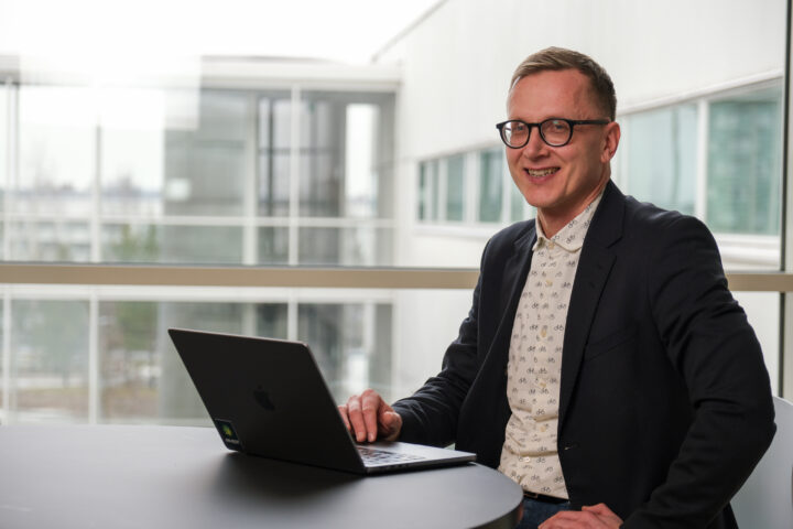 Jani Erola tietokoneen ääressä iloisena.