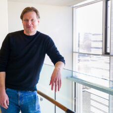 Picture of Laaninen smiling moderately in a corridor at the University