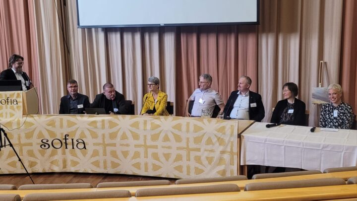 Ihmisiä rivissä paneelikeskustelussa.