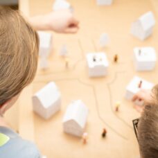 Tunnistamattomat tutkijat tutkivat kaupungin pienoismallia.