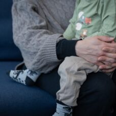 Lapsi aikuisen sylissä, kuvassa ei näy päät